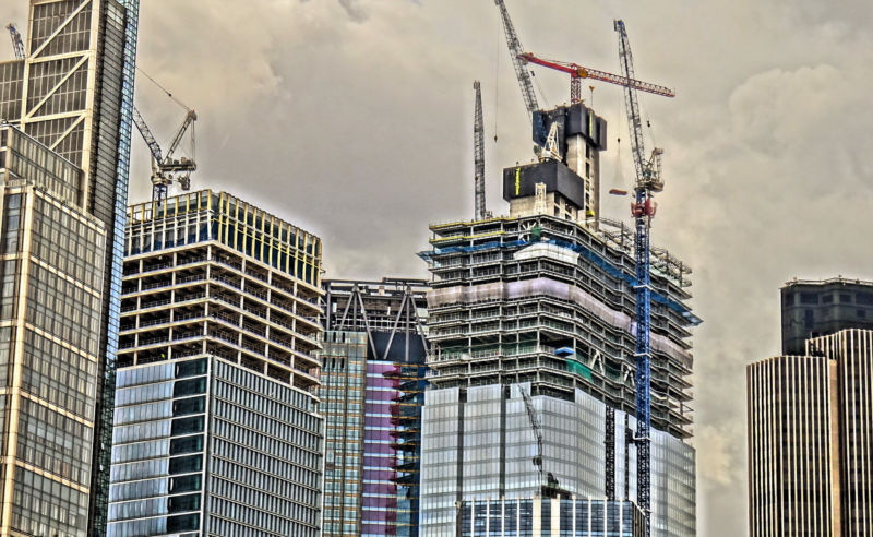 Stylized image of glass skyscrapers under construction.