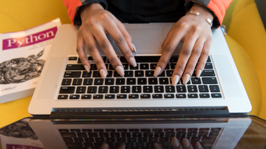 Hands on a keyboard with a Python book Hands on a keyboard with a Python book