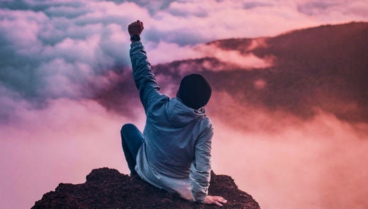 Person on top of a mountain, arm raise