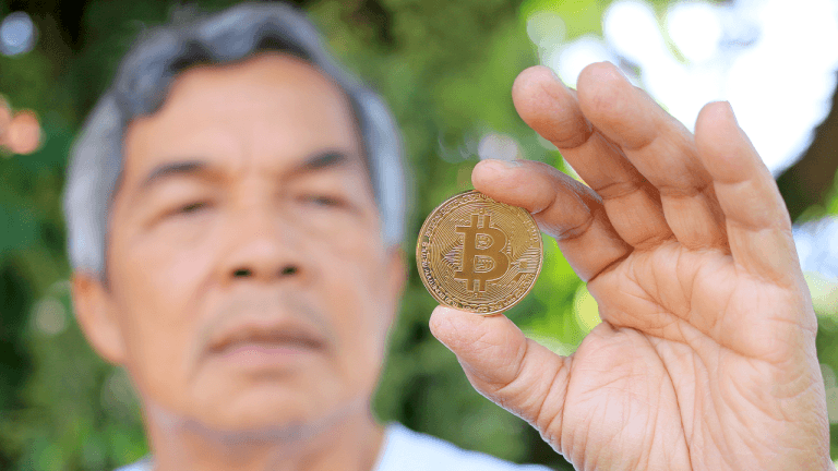 Man holding a physical bitcoin.